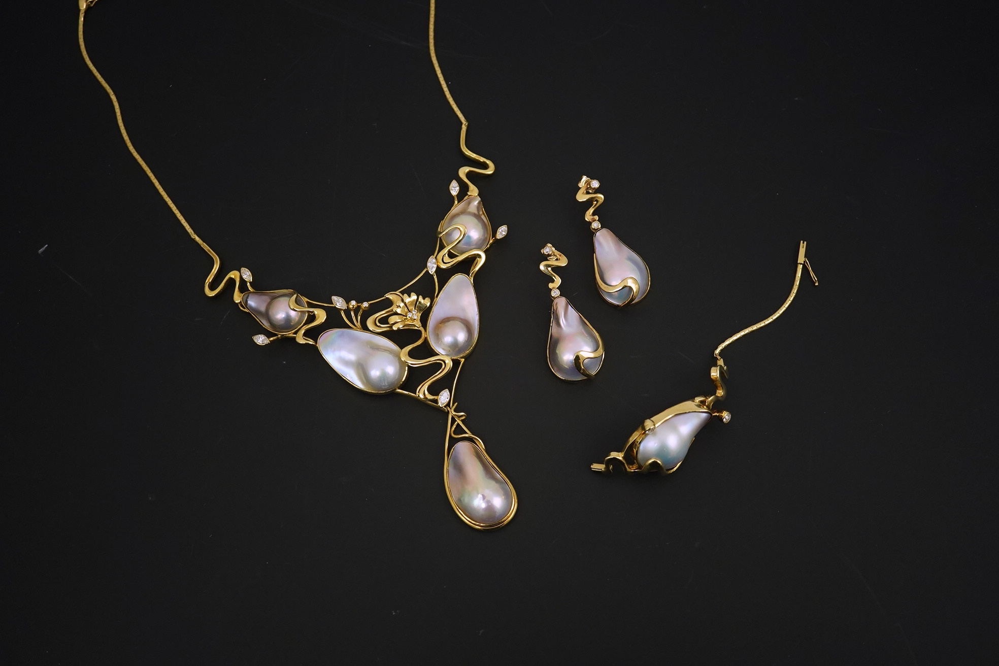 A modern suite of 18k gold, baroque pear, round and marquise diamond set jewellery